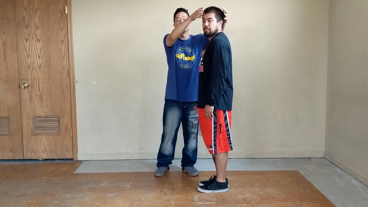 Ceech guiding a student’s head position during a Neck-O-Flex dance lesson